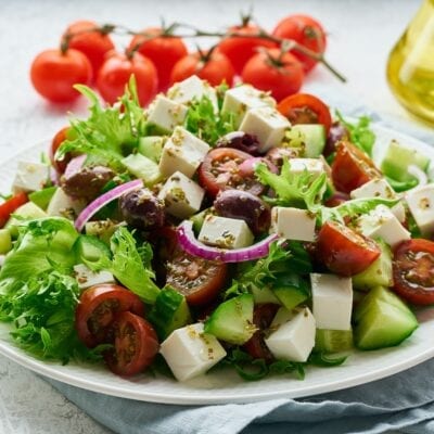 Greek Salad with feta and tomatoes, dieting food on white background closeup