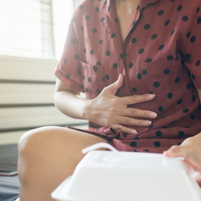 Woman with stomach pain after eating