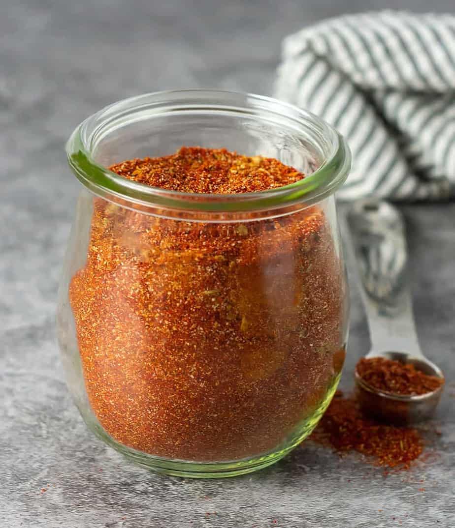 homemade chili powder blend on a tablespoon and in a glass jar. 